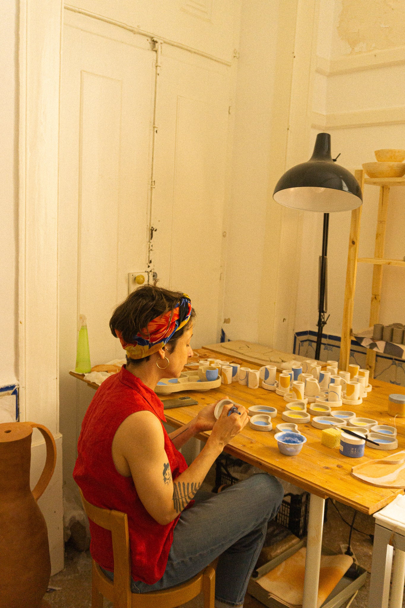 Tatiana dans son atelier lisboète en train de peindre les tasses à café en céramique