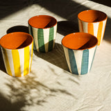 Grandes tasses sans anse en céramique, fabriquée et peinte à la main au Portugal. Blanches avec des rayures colorées, et intérieur terracotta.