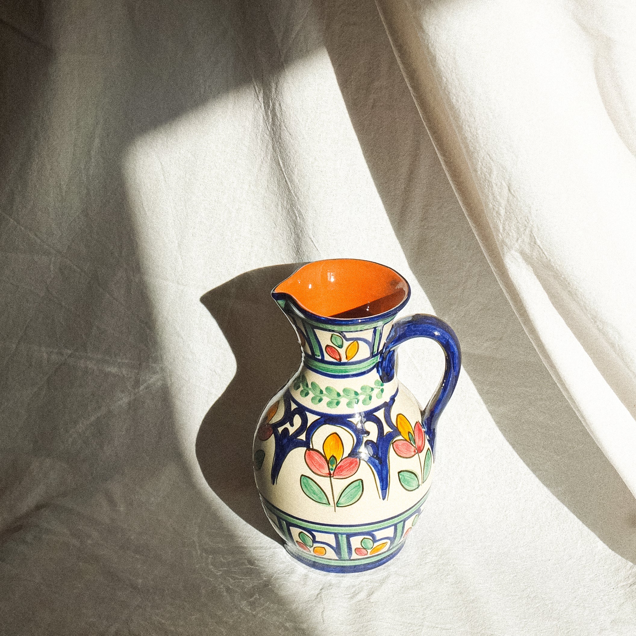 Carafe en terre cuite fabriquée et peinte à la main au Portugal. Contenance de 1 litre. Motifs floraux colorés. 