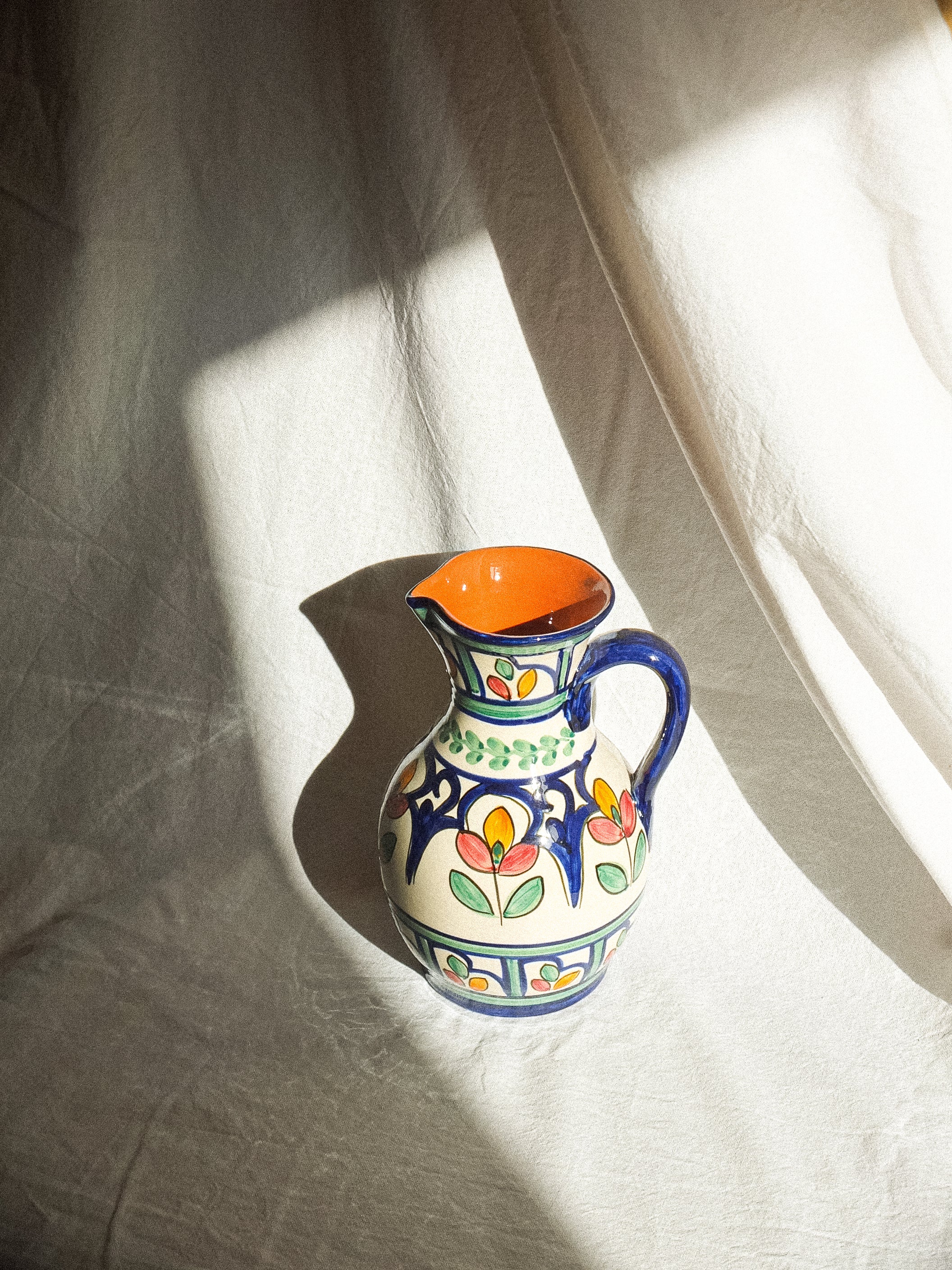Carafe en terre cuite fabriquée et peinte à la main au Portugal. Contenance de 1 litre. Motifs floraux colorés. 