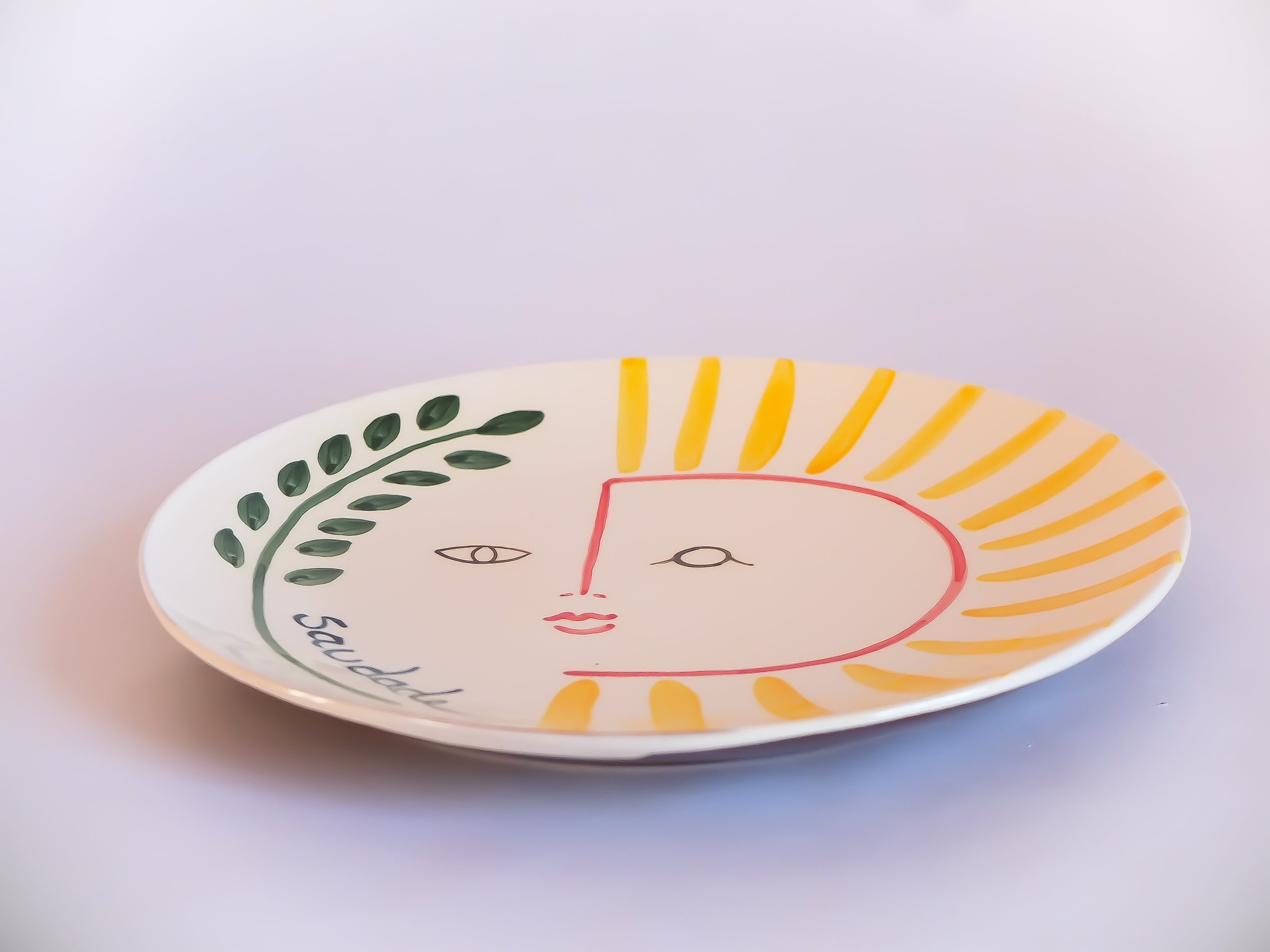 Assiette plate en céramique fabriquée et peinte à la main dans la région portugaise de l'Alentejo. Illustration soleil