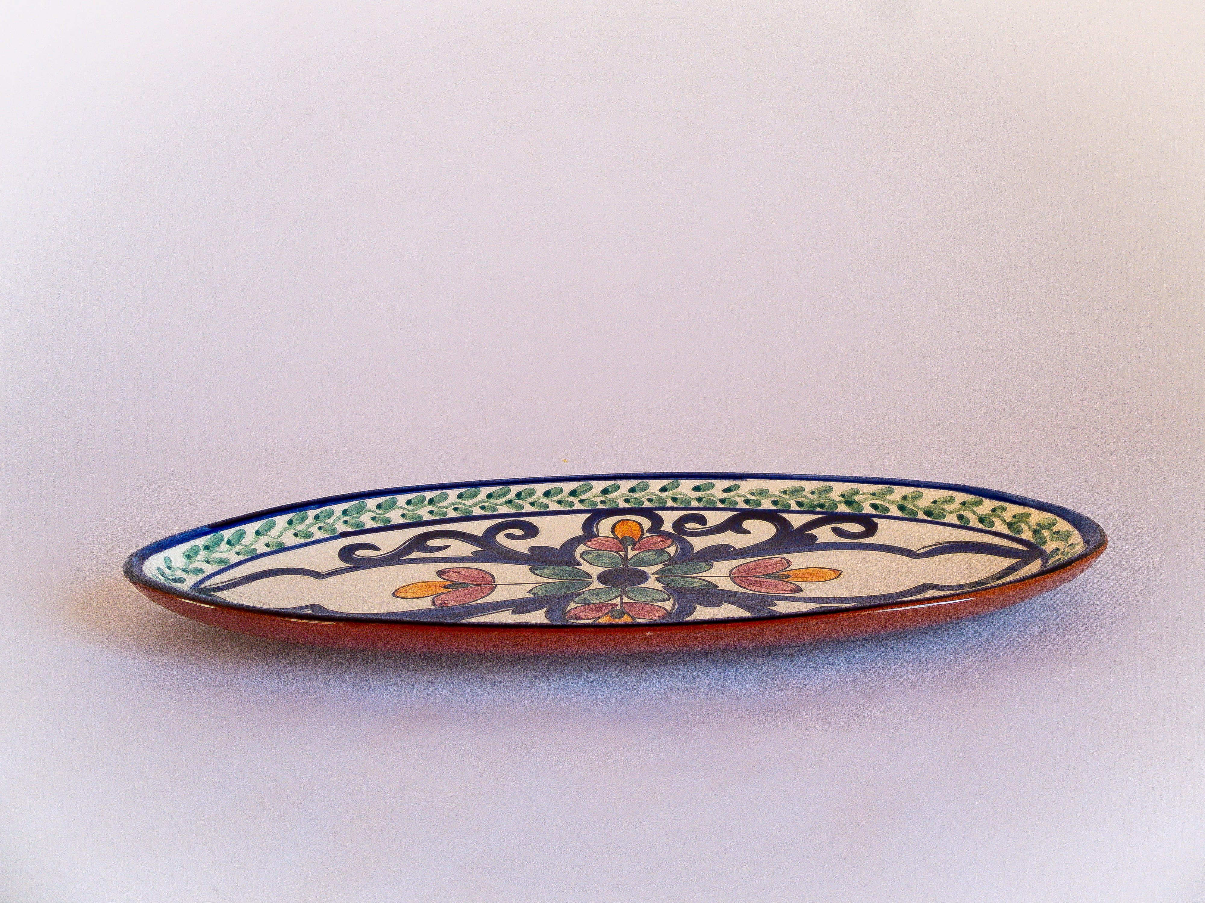 Plat de présentation oval fabriqué et peint artisanalement au Portugal, à motifs floraux et colorés