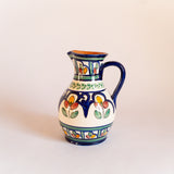 Carafe en céramique fabriquée et peinte à la main au Portugal. Contenance 1L. Motifs floraux colorés.