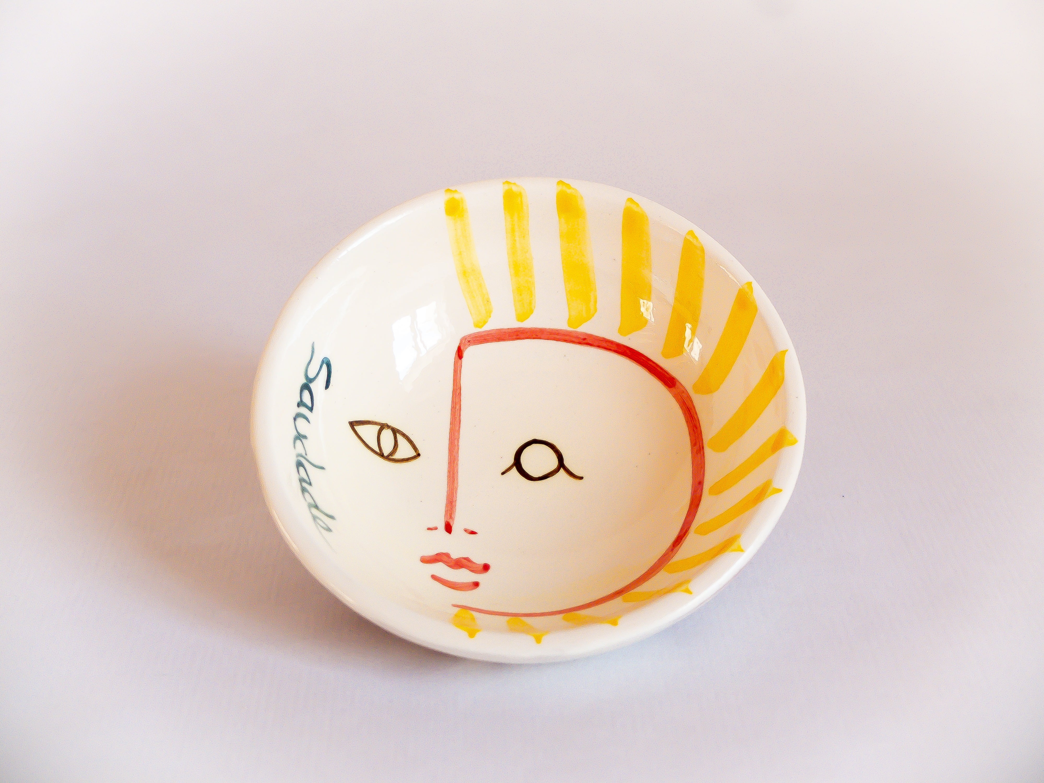 Petit bol en terracotta, fabriqué au tour de potier et peint à la main dans une olaria traditionnelle portugaise. Représente un visage soleil