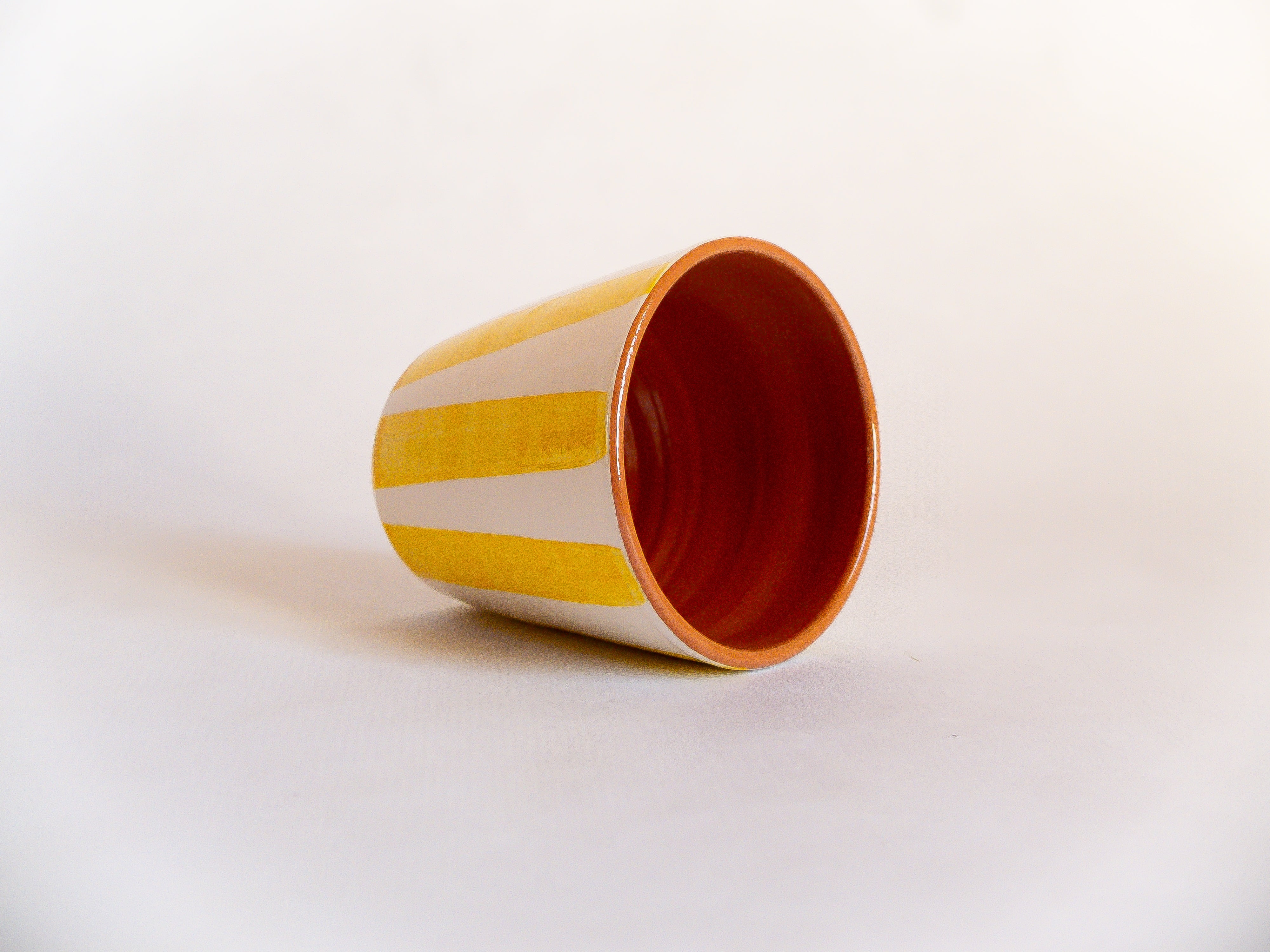 Grande tasse sans anse en céramique, fabriquée et peinte à la main par des artisans portugais. Blanche avec des rayures jaunes, intérieur argile rouge vernis.