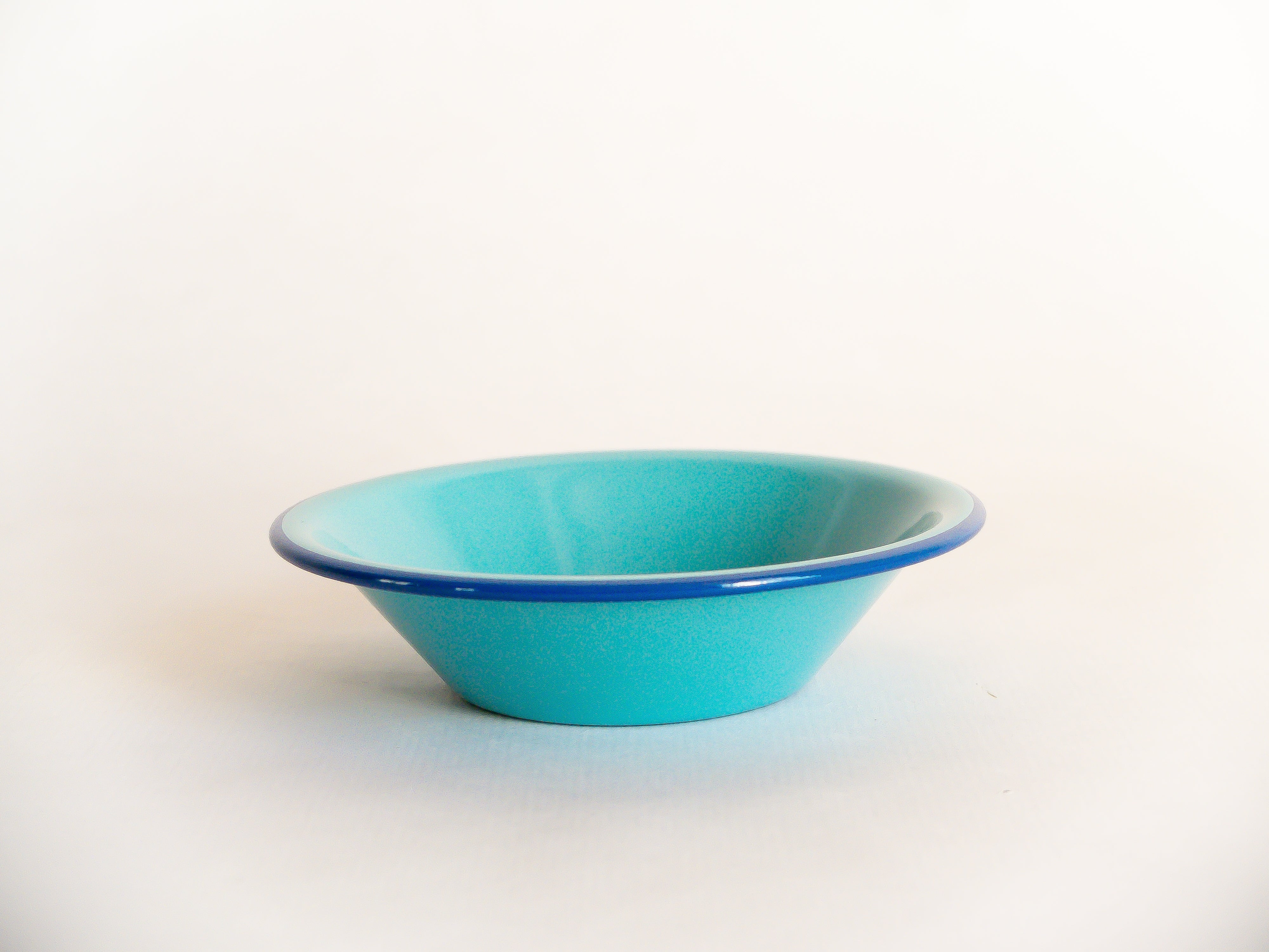Petit bol en métal émaillé incassable turquoise à rebord bleu foncé. Collection de vaisselle nomade, à emmener partout