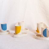 Ensemble à café, composé de tasses et coupelles aux formes organiques et couleurs pétillantes.