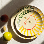 Assiette à dessert fabriquée et peinte à la main au Portugal. L'illustration peinte sur l'assiette représente un soleil.