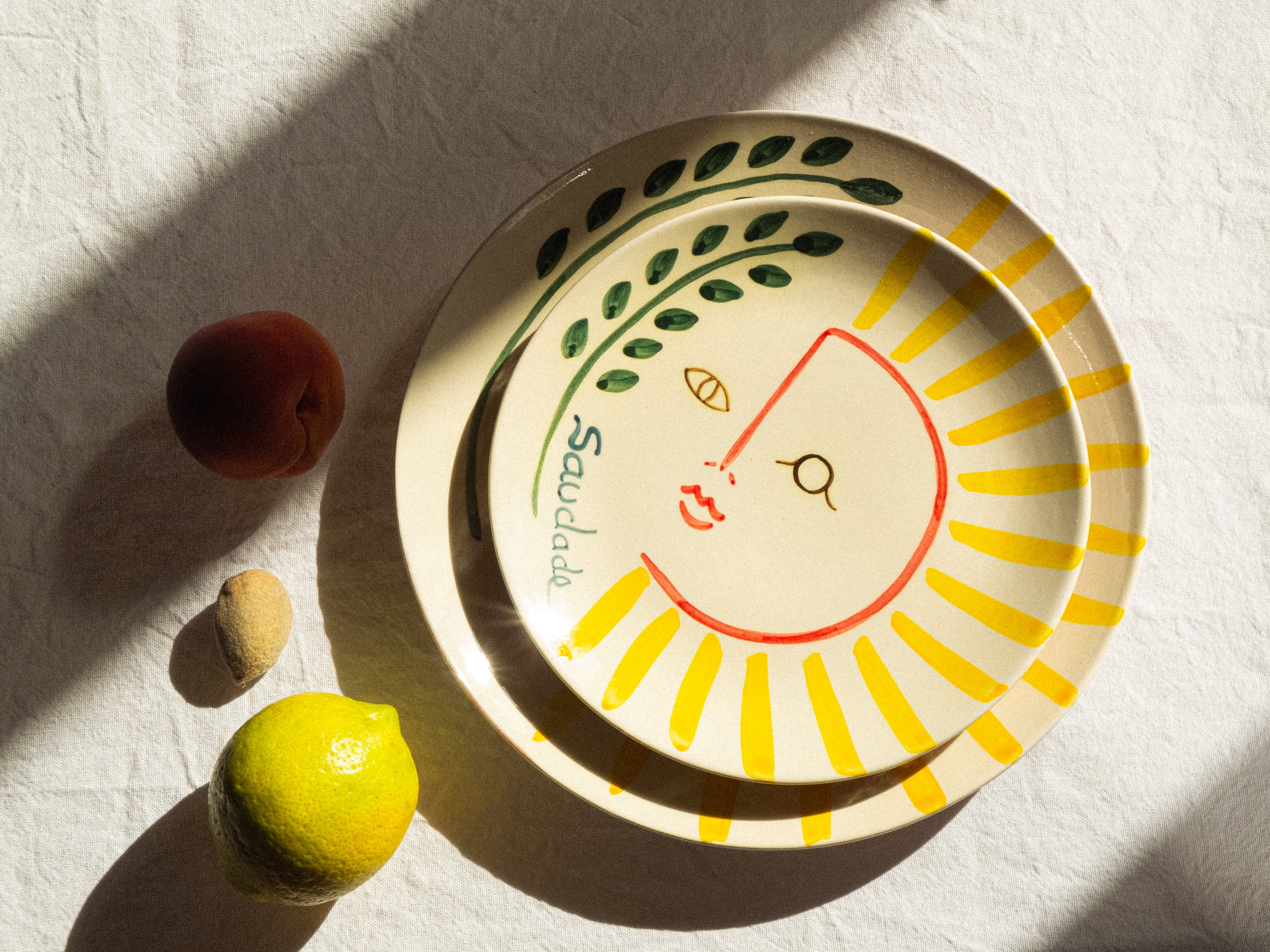 Assiette à dessert fabriquée et peinte à la main au Portugal. L'illustration peinte sur l'assiette représente un soleil.