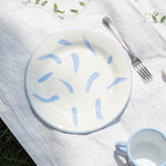 Assiette plate en émail, fabriquée et peinte à la maiN. Couleurs blanc et lila, avec des motifs coups de pinceau. Parfaite pour les pique-niques