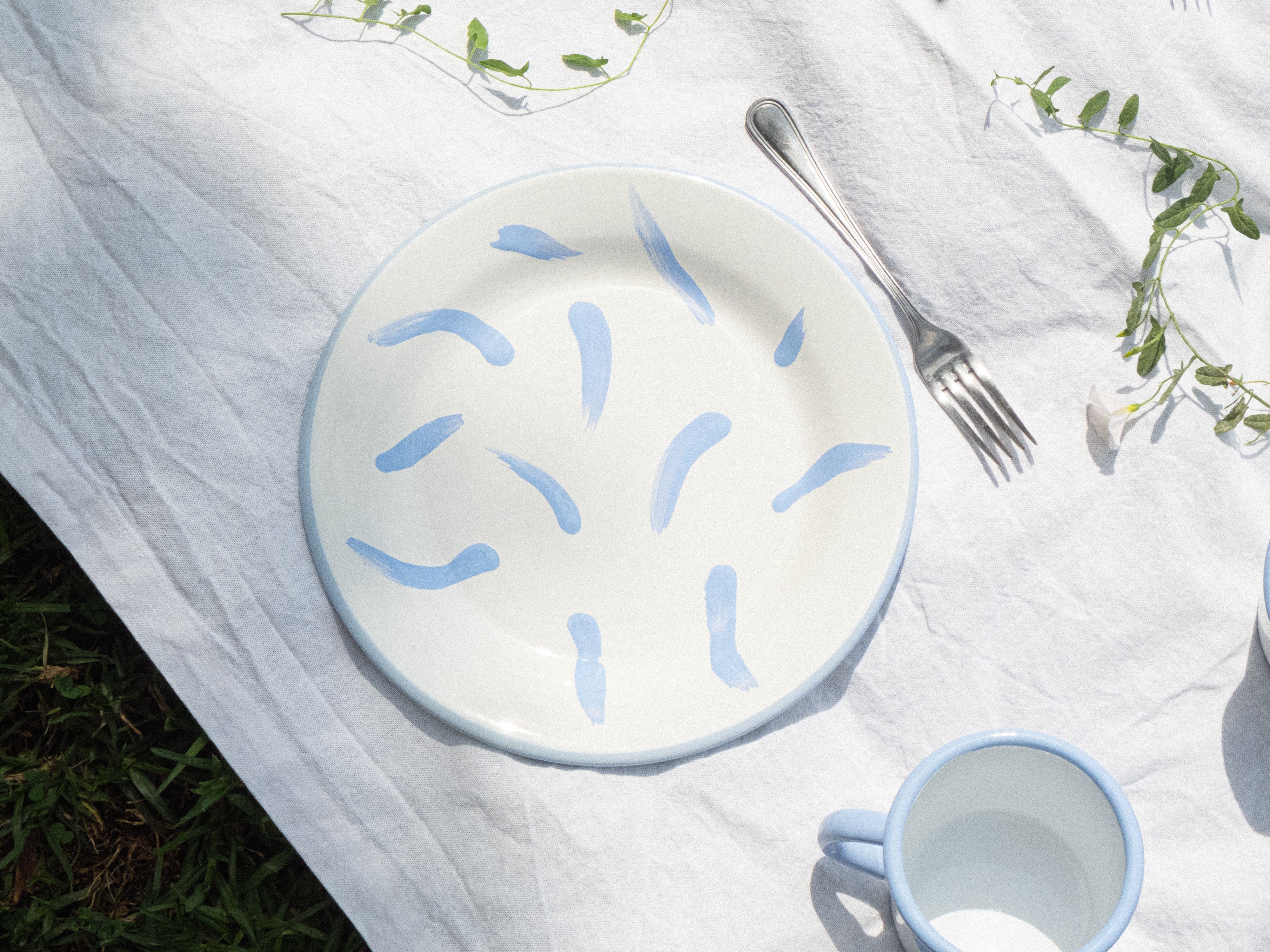 Assiette plate en émail, fabriquée et peinte à la maiN. Couleurs blanc et lila, avec des motifs coups de pinceau. Parfaite pour les pique-niques