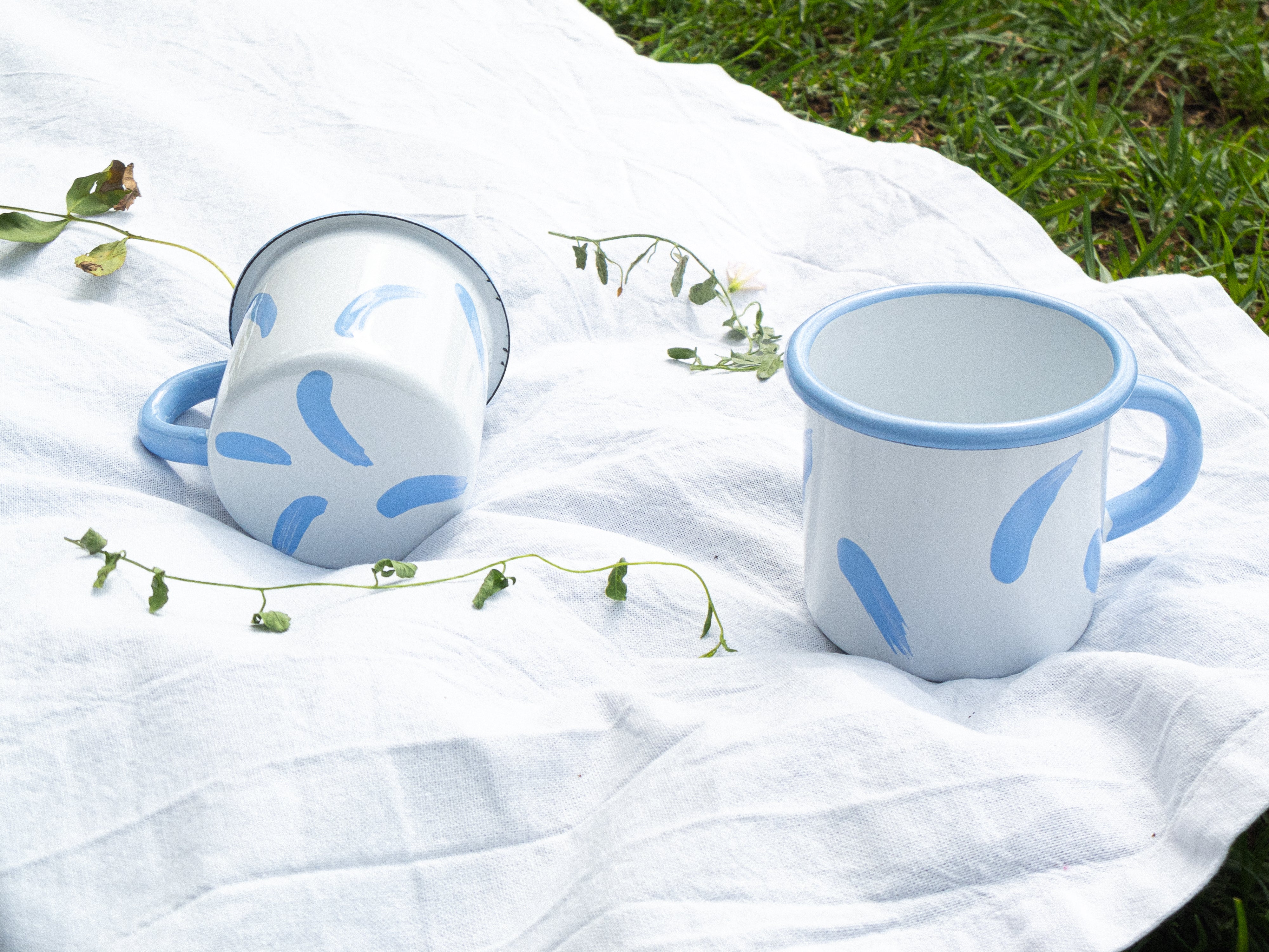 Tasse en émail blanche et coups de pinceaux lilas, fabriquée et peinte artisanalement au Portugal. Transportez votre tasse nomade partout avec vous !